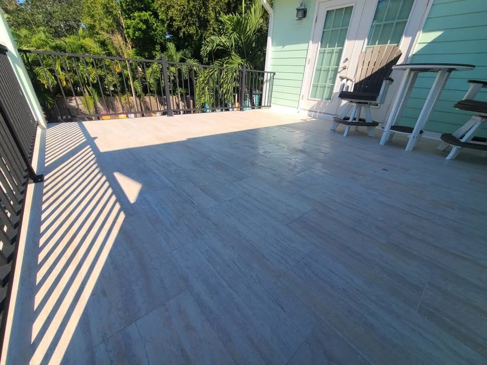 Outdoor deck with gray tile flooring and white railing