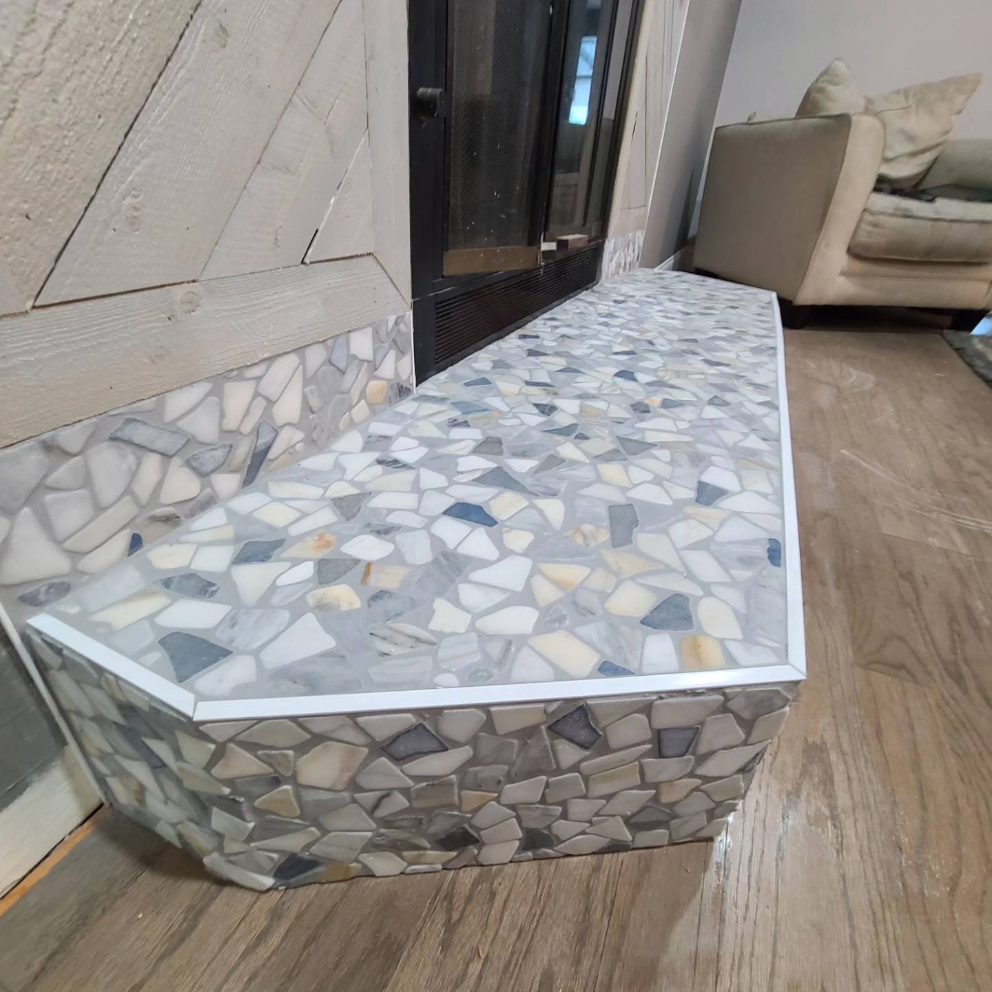 Close-up of finished fireplace hearth with decorative mosaic tile